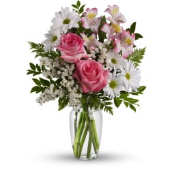 Pink roses and white daisies in a clear glass vase
