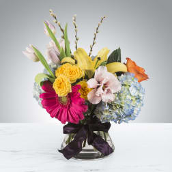 Mixed bouquet in a glass vase with a dark ribbon