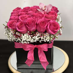 Hot pink roses arranged in a black box with a pink ribbon