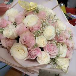 Bouquet of pink and white roses with decorative crown picks