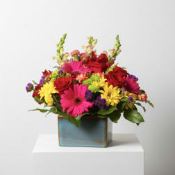 Colorful mixed bouquet in a square ceramic vase