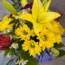 Bouquet of yellow lilies, daisies, and red blooms