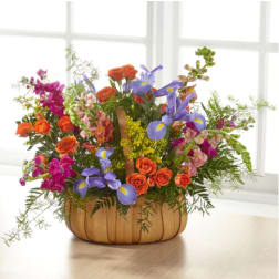 Mixed bouquet in a pumpkin-shaped wooden container with orange and purple flowers