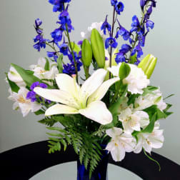 Blue and white flower arrangement in a tall cobalt vase