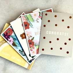 Stack of greeting cards with floral prints and birthday, anniversary, and congrats text