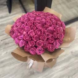Large bouquet of pink roses wrapped in brown paper