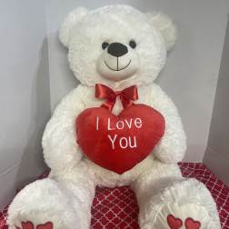 White teddy bear holding a red heart that says I Love You