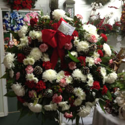 Large holiday wreath with white and red flowers and a red bow