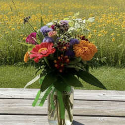 Mixed bouquet of bright flowers in a clear glass vase