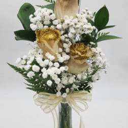 White baby's breath arrangement with gold-dusted roses in a glass vase