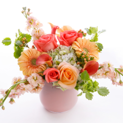 Pink and peach flower arrangement in a round vase
