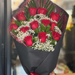 Bouquet of red roses with baby's breath wrapped in black paper