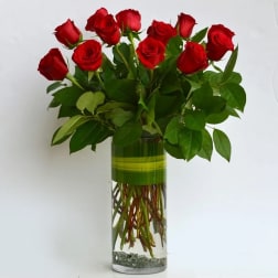 Red roses arranged in a tall glass vase