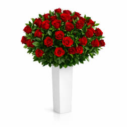 Red rose arrangement in a tall white pedestal vase