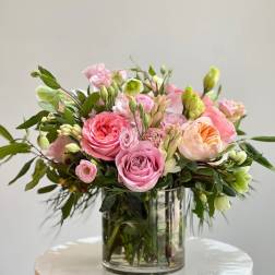 Pink and peach roses arranged in a clear glass vase