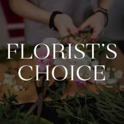 Florist arranging pink and white roses on a worktable