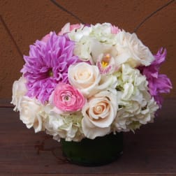 Pink, white, and purple flower arrangement in a dark vase