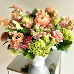 Peach and pink mixed bouquet in a white vase