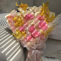 Bouquet of pink roses with pale filler flowers and gold leaves