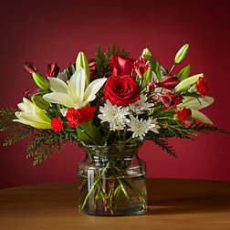 Red roses and white lilies arranged in a glass vase