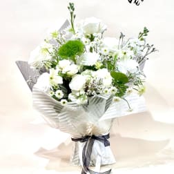 White bouquet with roses and small daisies wrapped in striped paper
