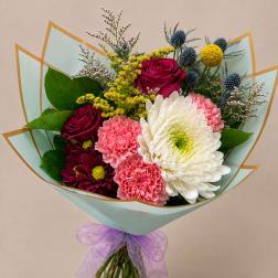 Bouquet of pink and white flowers wrapped in pale blue paper with a purple ribbon