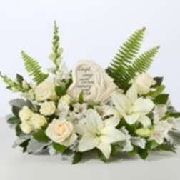White floral sympathy arrangement with lilies and roses around a memorial plaque