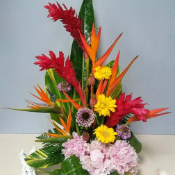 Tropical flower arrangement with red ginger, bird of paradise, yellow daisies, and pink hydrangeas