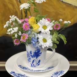 Mixed bouquet in a blue-and-white mug on a matching plate