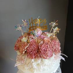 Pink and white floral cake with a happy birthday topper