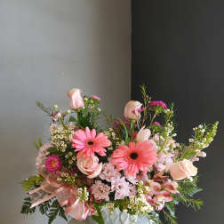 Pink mixed bouquet in a low vase with gerbera daisies and roses