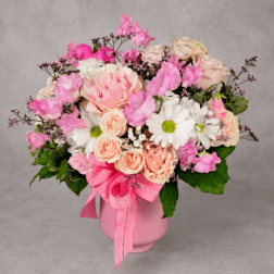 Pink and peach bouquet in a pink vase with a ribbon