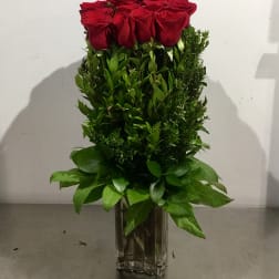 Tall bouquet of red roses in a clear glass vase