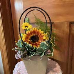 Basket arrangement with sunflowers and mixed greenery in a kraft paper container