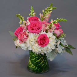 Pink roses and white hydrangeas in a green glass vase