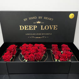 Black gift box with red roses arranged inside