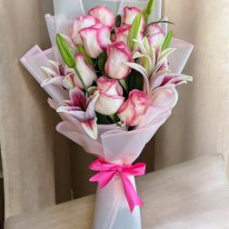 Pink and white rose bouquet with lilies wrapped in pale pink paper