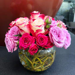 Pink and cream roses arranged in a clear glass vase
