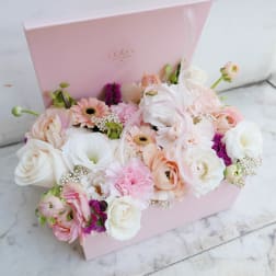 Pastel flower arrangement in a pink gift box with roses and gerbera daisies