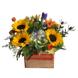 Mixed bouquet with sunflowers, lilies, and orange roses in a wooden box