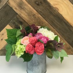Mixed pink and white flowers arranged in a ribbed metal vase
