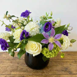 Purple and white mixed bouquet in a dark vase