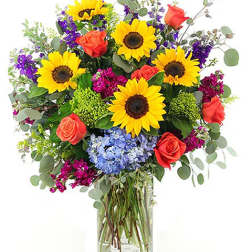 Bouquet of sunflowers and roses in a clear glass vase