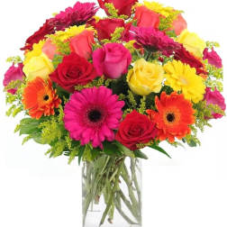 Mixed bouquet of roses, gerbera daisies, and mums in a clear glass vase