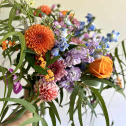 Handheld bouquet with orange, purple, pink, and blue flowers