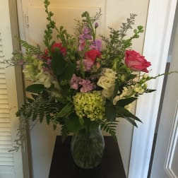 Mixed bouquet of pink, white, and purple flowers in a glass vase