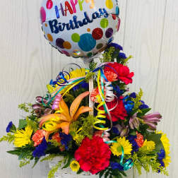 Birthday balloon above a colorful flower basket arrangement
