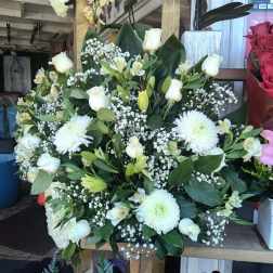 White floral arrangement with roses, lilies, and chrysanthemums