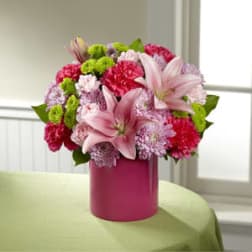 Pink lilies and carnations in a magenta vase
