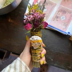 Small dried flower bundle wrapped with yellow cord and a shell accent